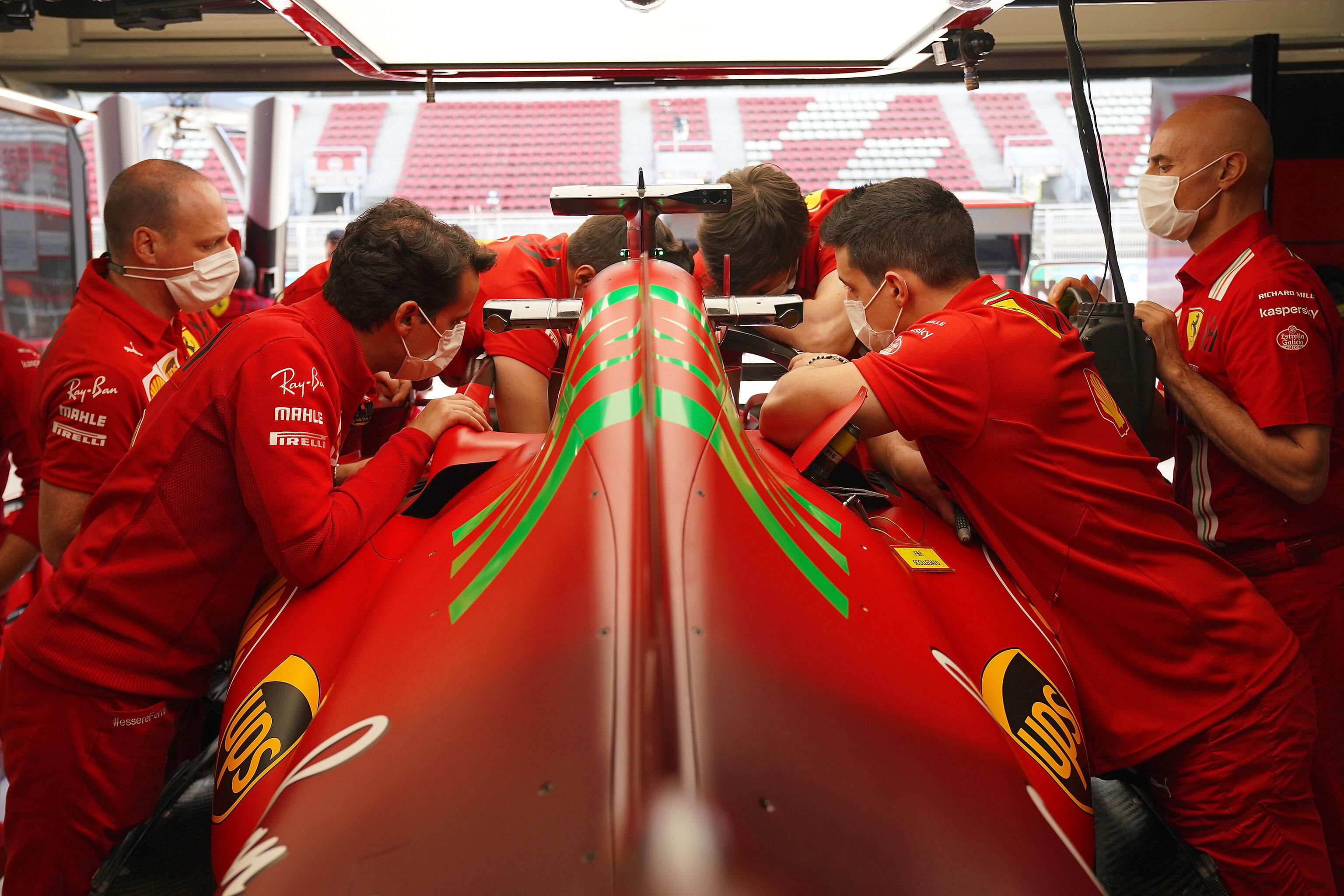 Ferrari mechanics have a look inside the cockpit of the SF21.: formula1